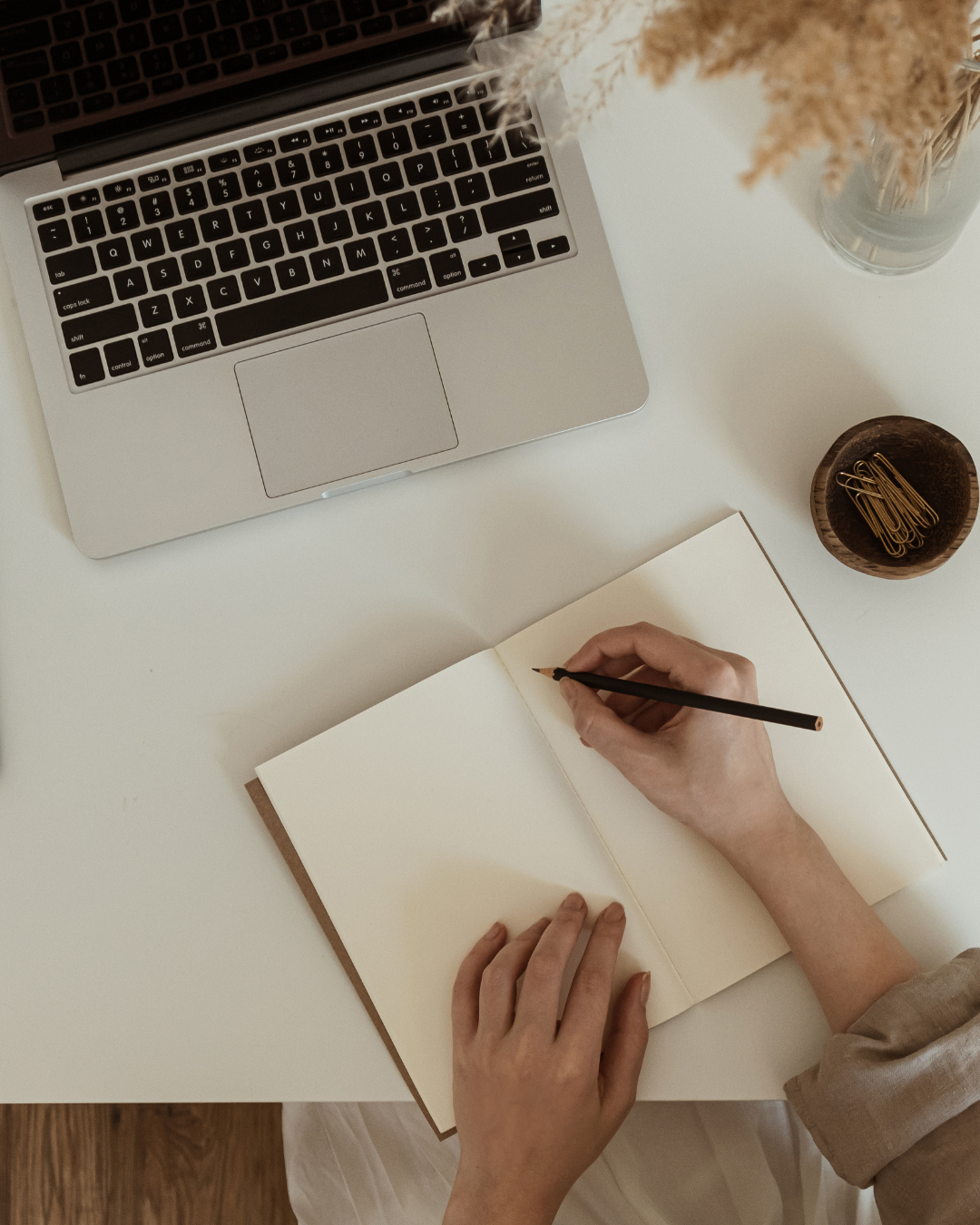 Woman writing in a journal on a desk